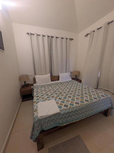 a bedroom with a bed with a green comforter at Amore Holiday Home in Canacona