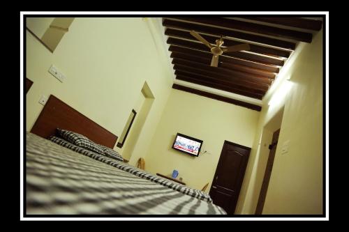 a bedroom with a bed and a ceiling fan at Pattiah Naidu Palace in Palani