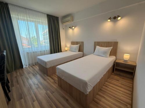 a hotel room with two beds and a window at Steluta in Eforie Nord