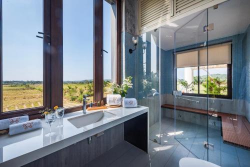 a bathroom with a sink and a glass shower at SaffronStays Citadel in Sangolda