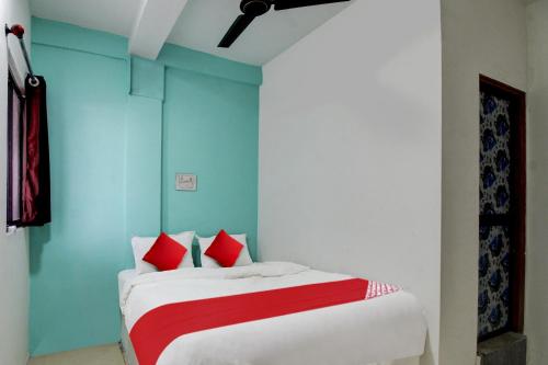 a bedroom with a bed with red and white pillows at Hotel O Kings in Pānchgaon