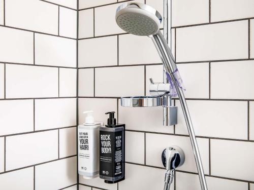 a bathroom sink with a blow dryer and a shower at ibis Epinal Centre in Épinal