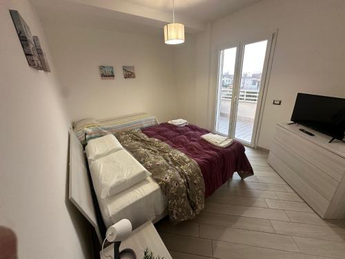 a bedroom with a bed and a television in it at Portunno Relax House in Fiumicino