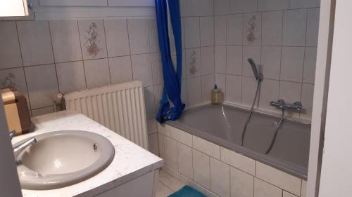 a bathroom with a sink and a bath tub at Entre Golf et Mer RDC in Dieppe