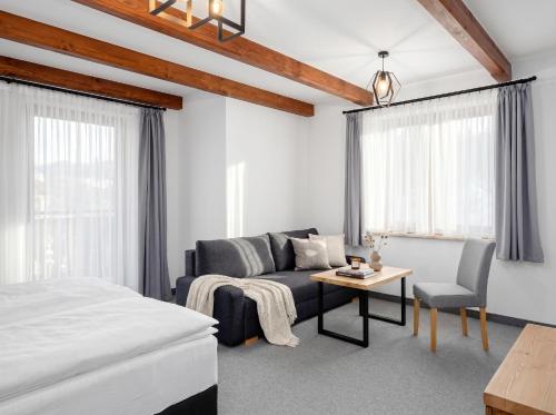 a bedroom with a bed and a couch and a table at Golden Apartments - Villa Taternik - Tatry View in Zakopane