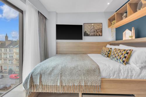 a bedroom with a bed and a flat screen tv at The Bonnie in Glasgow