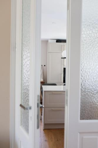 a kitchen with white appliances and a white door at Altes Winzerhaus Stegmann in Sankt Martin