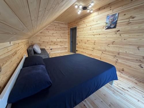 a bedroom with a bed in a wooden room at Pulmo Rest House in Pulʼmo