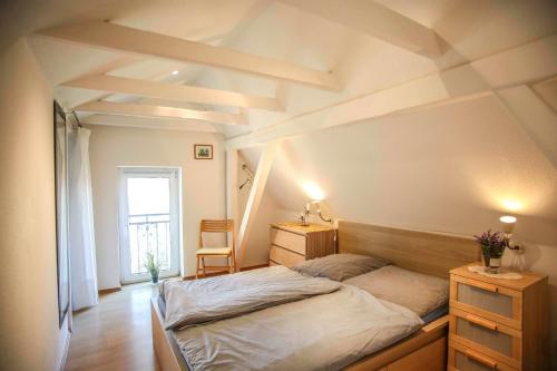 a bedroom with a bed and a desk and a window at Ferienwohnung Wieben in Sankt Peter-Ording