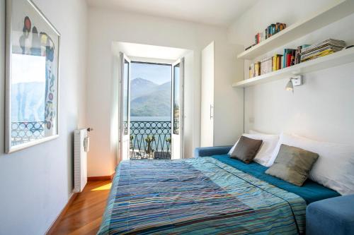 a bedroom with a bed and a large window at Piazzetta Lake View by Halldis in Dongo