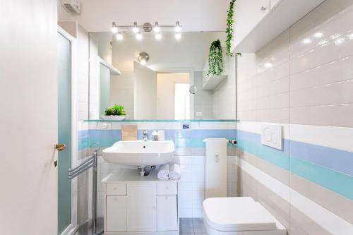 a bathroom with a sink and a toilet and a mirror at Piazzetta Lake View by Halldis in Dongo