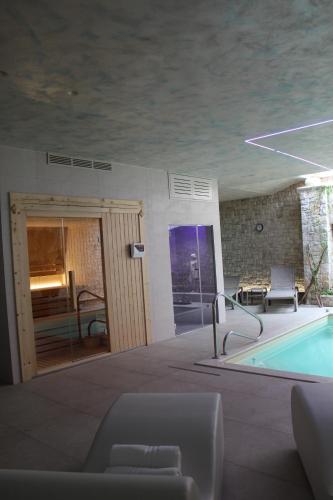 a room with a pool and a table and chairs at Pietra Viva Suite e Relax in Veglie