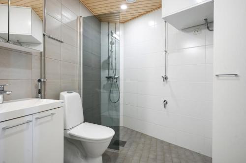 a white bathroom with a toilet and a shower at Modern Arctic Studio By Lapland Host in Rovaniemi