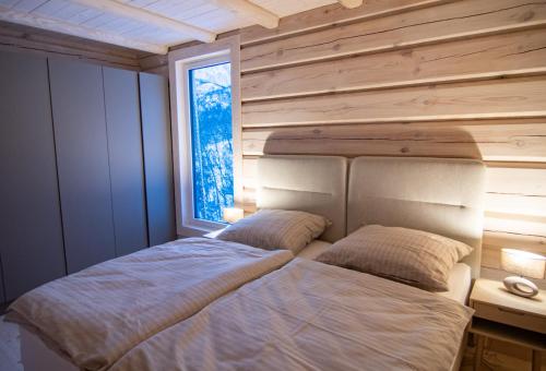 two beds in a bedroom with a window at Sommarbukt Tind - Luxury Fjord Lodge near Tromsø in Tromsø