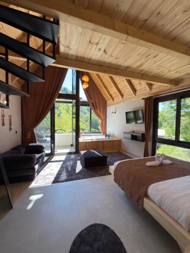 a bedroom with a large bed in a room with windows at Ponte Butik Otel in Çamlıhemşin