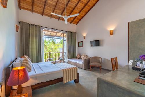 a bedroom with a bed and a living room at Tartaruga Beach Unawatuna in Unawatuna