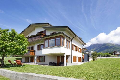 a large white house with a grass yard at La Veranda - Alpago in Pieve dʼAlpago
