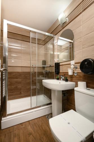 a bathroom with a shower and a toilet and a sink at One Luxury Suites AKUSTIK - 3 minuta peške do Jezera in Zlatibor