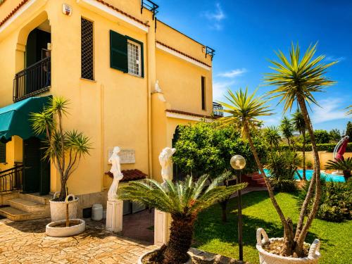 a house with palm trees in front of it at Villa SOLE di AMORE - POOL PRIVATE LARGE 100 M 2 - Beach 950m -Center 500 m - ROME & AIRPORT 39 km in Anzio