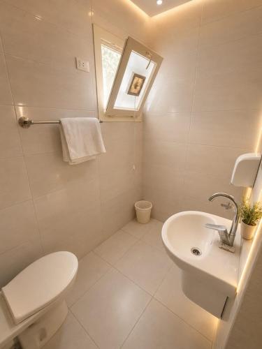 a bathroom with a white toilet and a sink at vila hotel city in Cairo