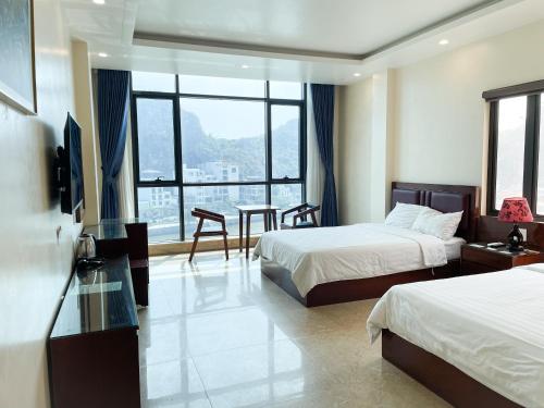 a hotel room with two beds and a table at Song Nga Boutique Hotel Cat Ba in Cat Ba