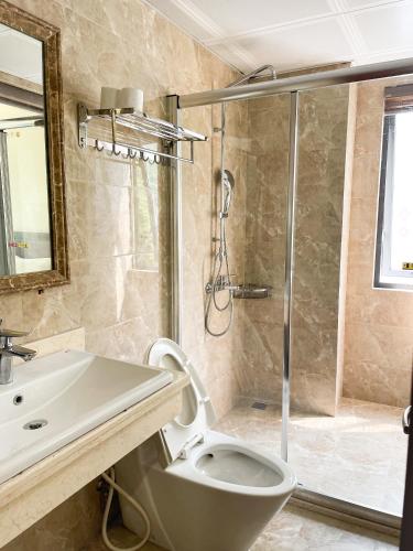 a bathroom with a shower and a toilet and a sink at Song Nga Boutique Hotel Cat Ba in Cat Ba