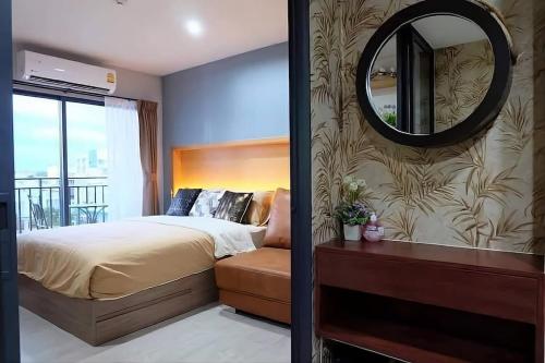 a bedroom with a bed and a mirror on a wall at Exclusive Condo with Pool - Self Check-in in Hua Hin