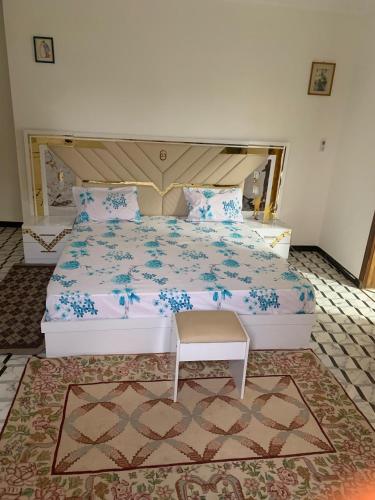 a bedroom with a large bed with blue flowers at Le Wallo - Residence Sebi in Sébikhoutane