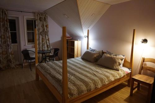 ein Schlafzimmer mit einem Bett mit einem Holzrahmen in der Unterkunft North Lake Villa Plateliai in Plateliai