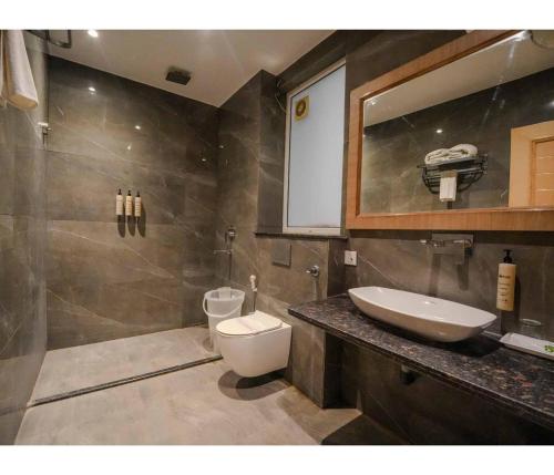 a bathroom with a sink and a toilet and a mirror at Sagar Resort in Alwar