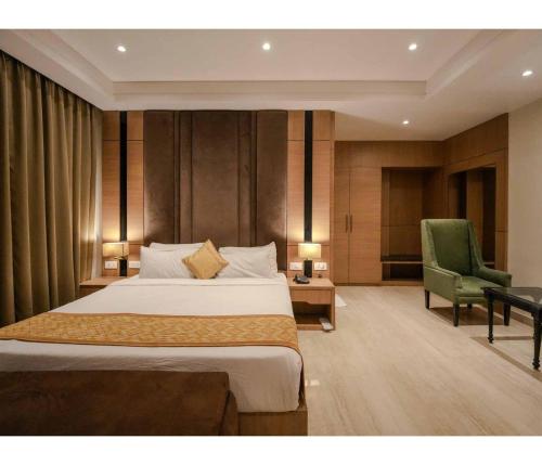 a hotel room with a bed and a green chair at Sagar Resort in Alwar