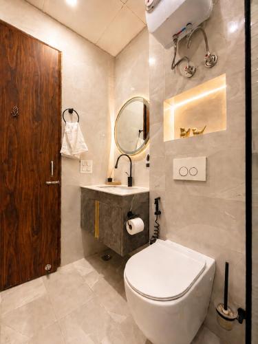 a bathroom with a toilet and a sink and a mirror at Ace Stayz - Boutique Hotel Near DLF Mall Sector 45, Noida in Noida