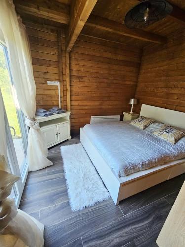 a bedroom with a bed and a wooden wall at Le Châlet Nature de Lieurey in Lieurey