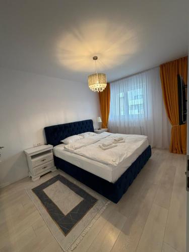 a bedroom with a large bed and a chandelier at Elite Noua in Braşov