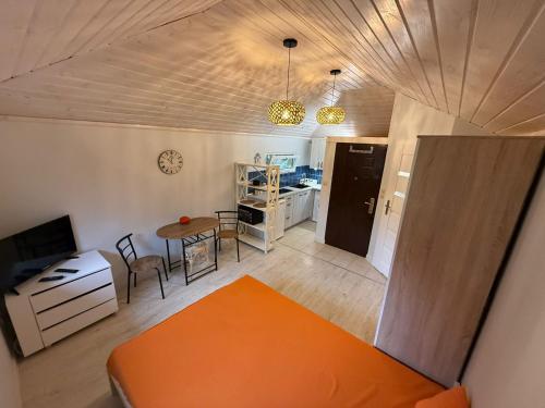 a living room with an orange couch and a table at Mini Apart - Gdańsk Jelitkowo in Gdańsk