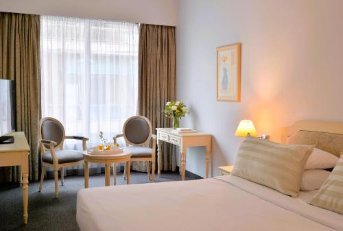a hotel room with a bed and a desk at Airotel Stratos Vassilikos Hotel in Athens