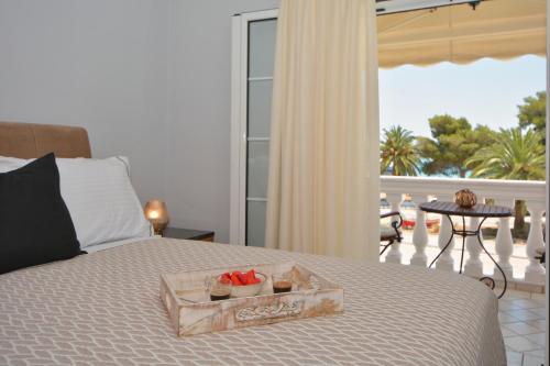 a tray of fruit on a bed in a bedroom at Vista Mare I in Porto Heli
