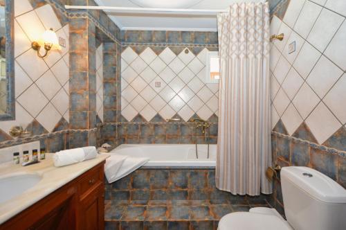 a bathroom with a tub and a toilet and a sink at Vista Mare I in Porto Heli