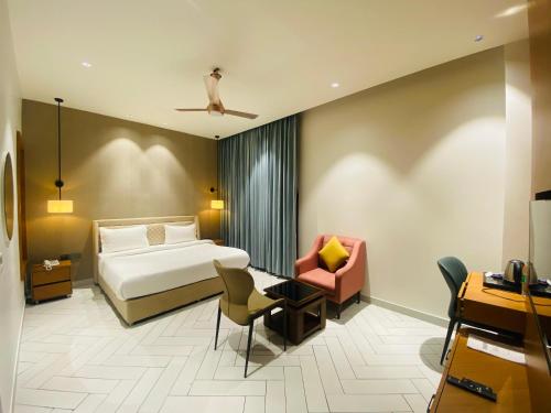 a hotel room with a bed and a chair at Royal palm hotel and resort in Niāl