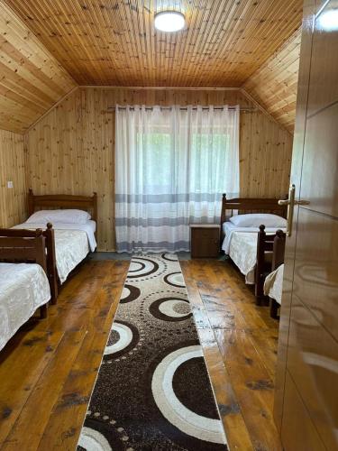 a room with two beds and a rug at Bujtina Turkaj in Nikshi