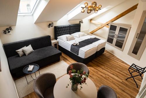 a room with a bed and a couch and a table at Arte Brno in Brno