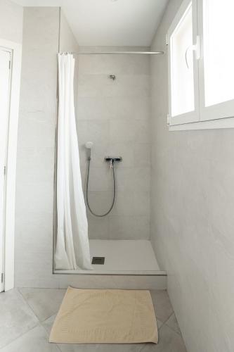 a bathroom with a shower with a shower curtain at Hostal Palmaria in Cala Santanyi