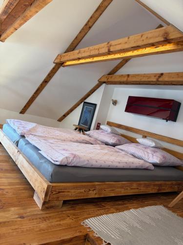 a bedroom with a large wooden bed in a attic at Apartmán Ateliér in Bílé Vchynice