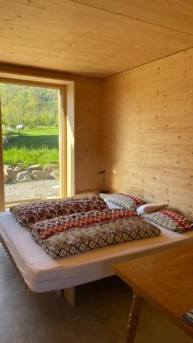 a large bed in a wooden room with a window at Refugium in Schwaigen