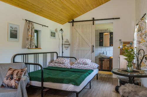 a bedroom with a bed and a couch and a table at Hetedhét Vendégház in Mórahalom