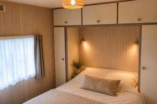 ein Schlafzimmer mit einem Bett und einem Kissen darauf in der Unterkunft Spa-Francorchamps Forest Lodge in Amel