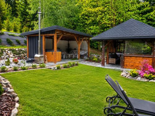a gazebo in a yard with a lawn at Biały Domek Świerczek - Jacuzzi, Balia Ruska SPA, Rowery, Altana i Grill w Słopnice in Słopnice