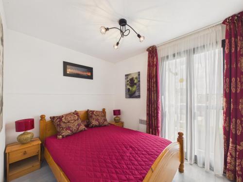 a bedroom with a bed with a pink bedspread at La Tranche-sur-Mer, maison pour 3 adultes-2 enfants in La Tranche-sur-Mer