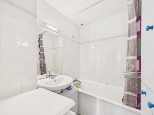 a white bathroom with a sink and a tub at La Tranche-sur-Mer, maison pour 3 adultes-2 enfants in La Tranche-sur-Mer