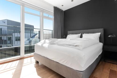 a bedroom with a white bed and a large window at B2 Apartments by Heimaleiga in Reykjavík